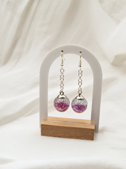 Pair of earrings with pink glass beads on a white background