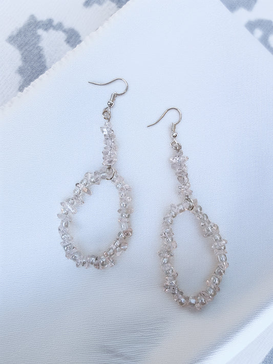 Pair of clear quartz beaded earrings on a light background