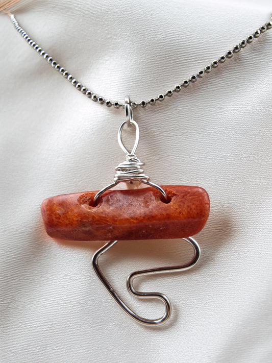 Necklace with a red stone pendant on a white background