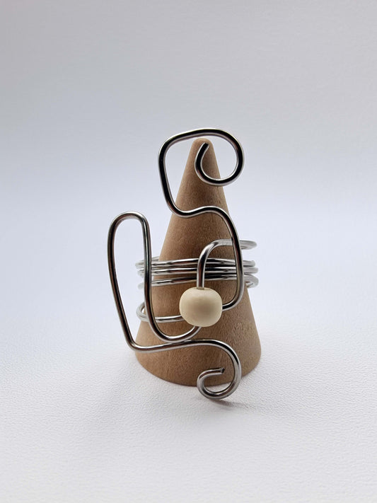 Silver wire bracelet with a pearl bead on a white background