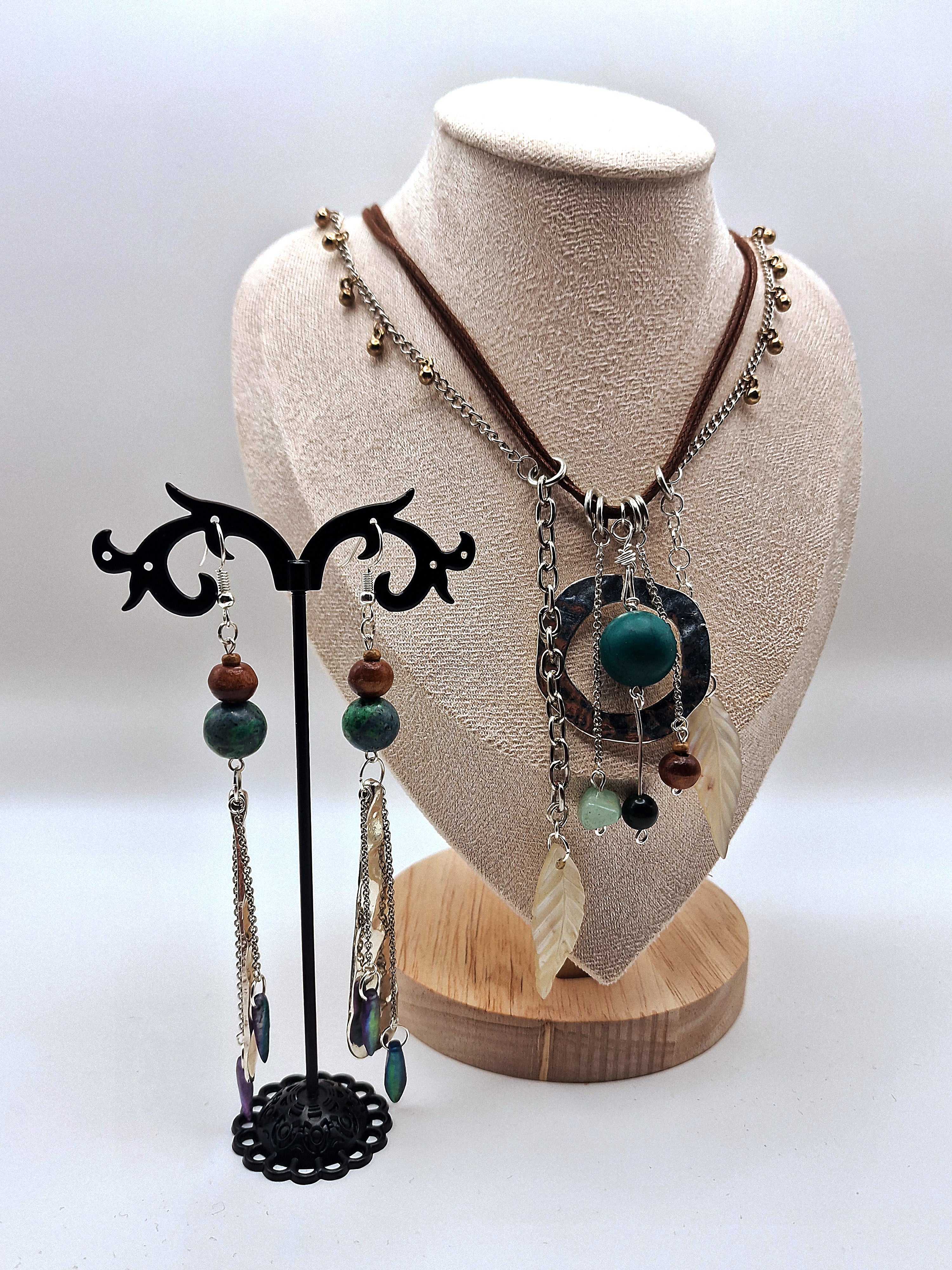 Necklace with pendant and earrings on a mannequin bust against a white background